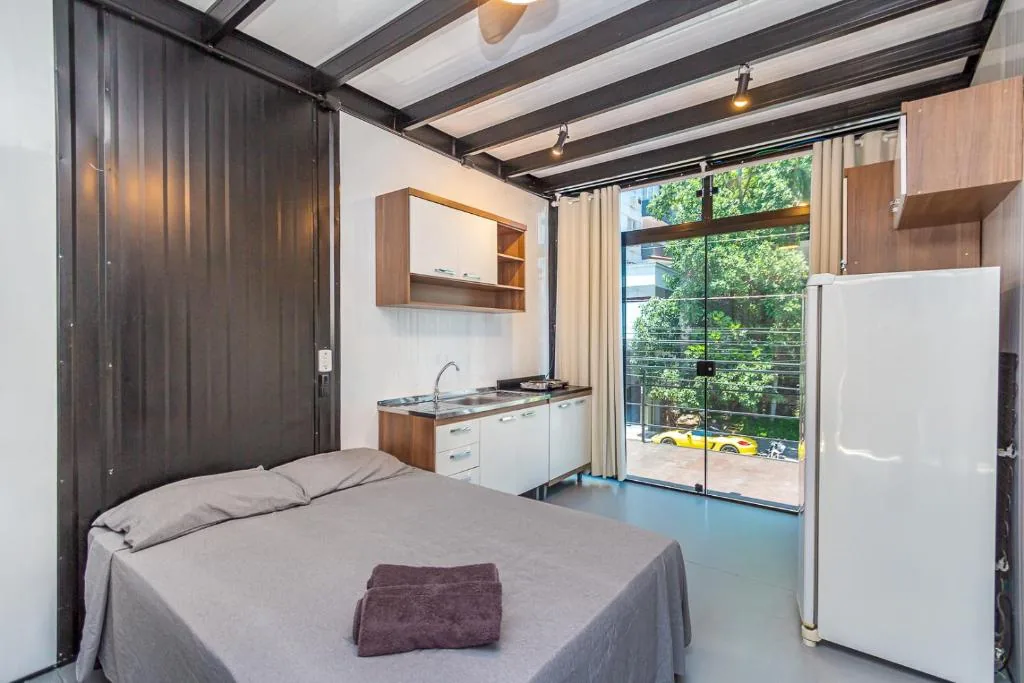Loft do andar superior: cama de casal, cozinha e porta de acesso ao terraço